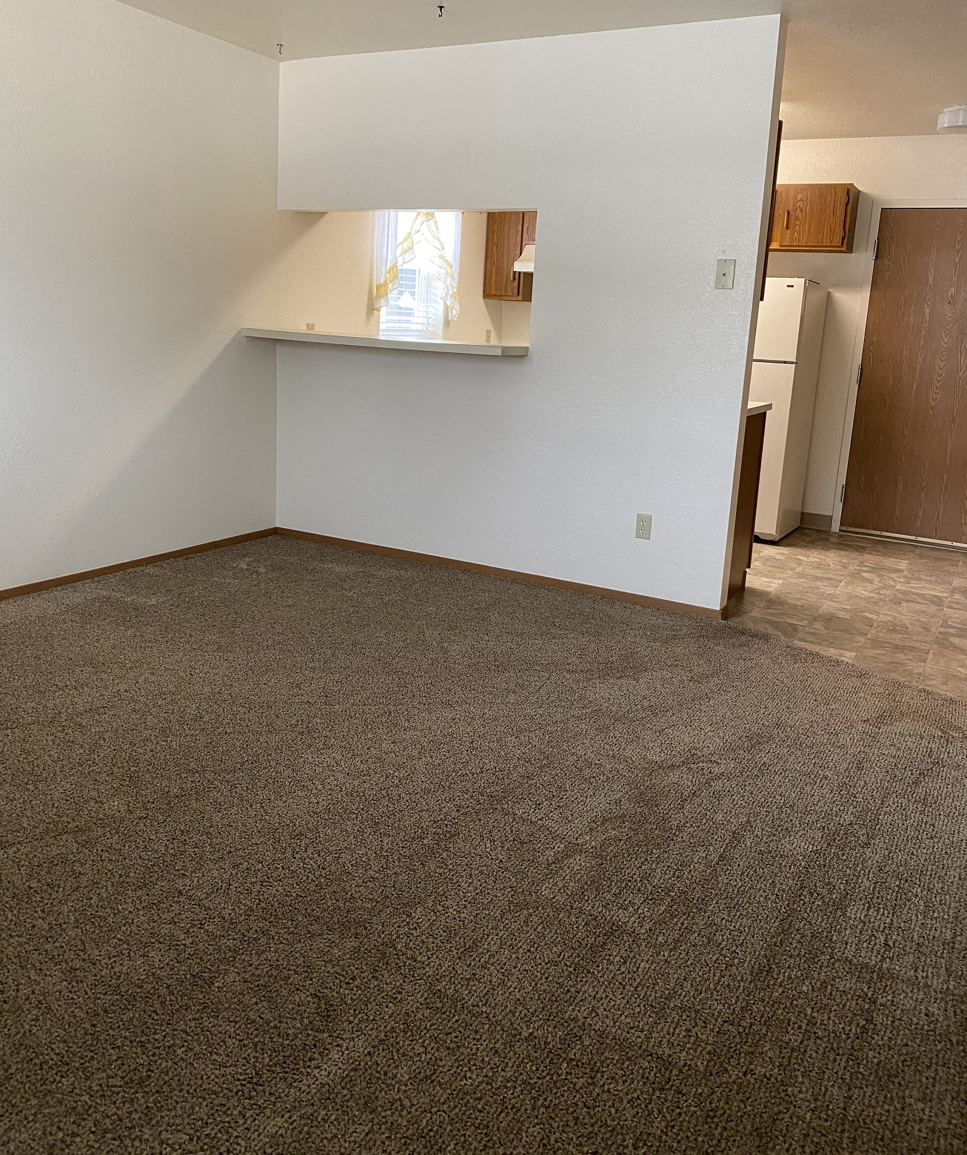 Image of carpeted room connected to kitchen